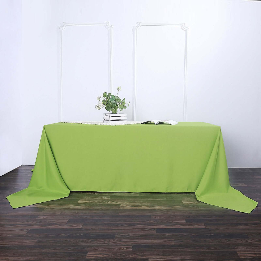 Green tablecloth draped over a table in a styled setting.