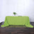 Green tablecloth draped over a table in a styled setting.