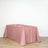 Pink tablecloth draped over a table with empty plates and glasses