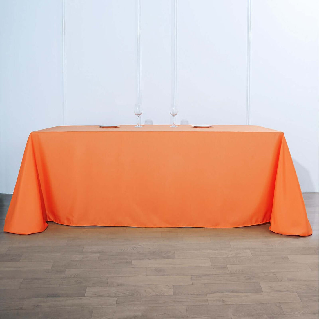 Orange tablecloth draped over a long table in a minimalist setting.