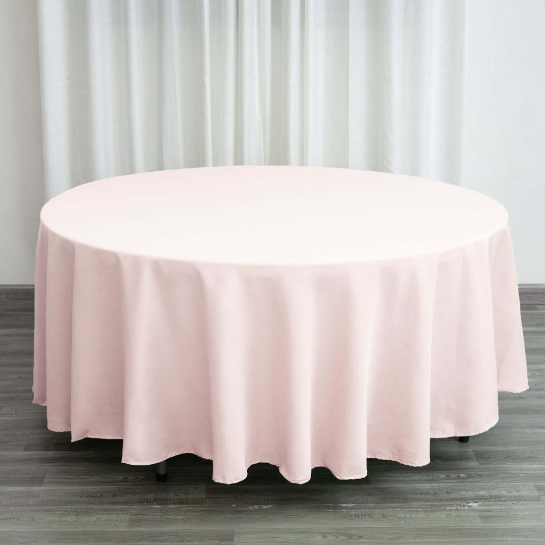 Round pink tablecloth draped elegantly over a circular table.