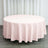 Round pink tablecloth draped elegantly over a circular table.