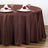 Brown tablecloth draped over a round table set with plates and napkins.