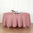 Round pink tablecloth draped elegantly over a dining table with decor.