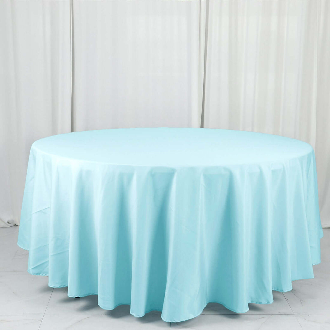 Round light blue tablecloth draped over a circular table
