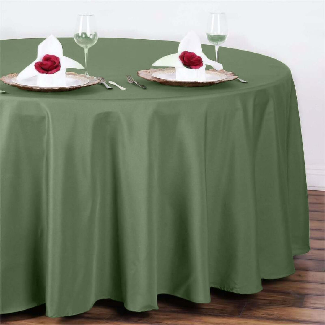 Olive green tablecloth set for elegant dining with rose-adorned napkins.