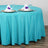 Turquoise tablecloth draped over a round table with elegant settings.