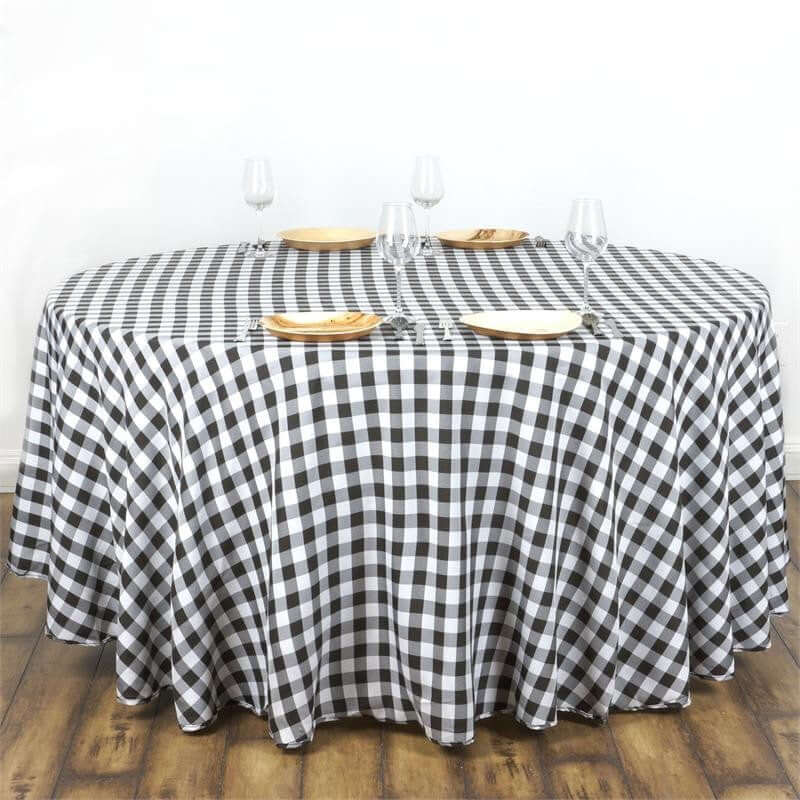 Black and white checkered tablecloth on a round table with plates and glasses.