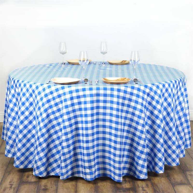 Blue and white checkered tablecloth draped over an oval table with plates and glasses.