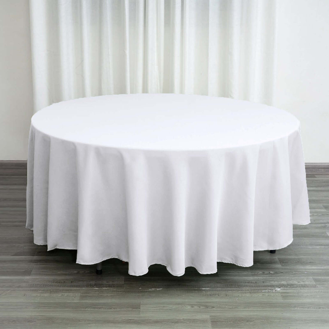 Round white tablecloth draping over a circular table