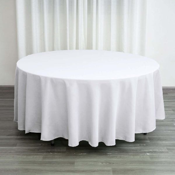 Round white tablecloth draping over a circular table