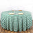 Green and white checkered tablecloth on a round table with plates and glasses.