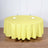 Round yellow tablecloth draped over a table with glasses and napkins
