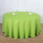 Round green tablecloth draped over a circular table with dining setup.