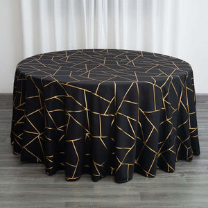 Black tablecloth with gold geometric pattern on a round table.