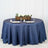 Round navy tablecloth styled with plates and decorative centerpiece.