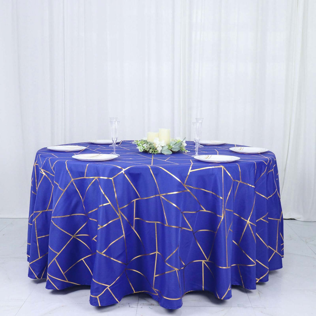 Blue tablecloth with gold geometric pattern on a round table.