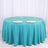 Round turquoise tablecloth with plates and glasses set on a white table.