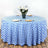 Blue and white checkered tablecloth on a round table with flowers and dinnerware.