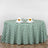 Green and white checkered tablecloth with napkins and glasses on a round table.