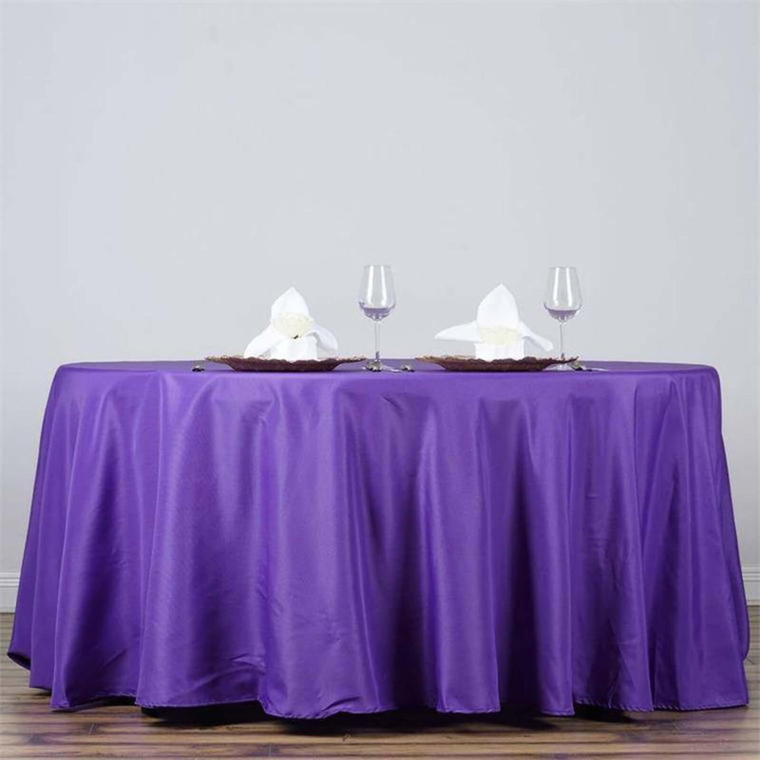 Purple tablecloth draped elegantly over a table with decorative napkins and glasses.