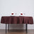 Elegant brown tablecloth set for a romantic dinner with wine glasses and rose-adorned napkins.