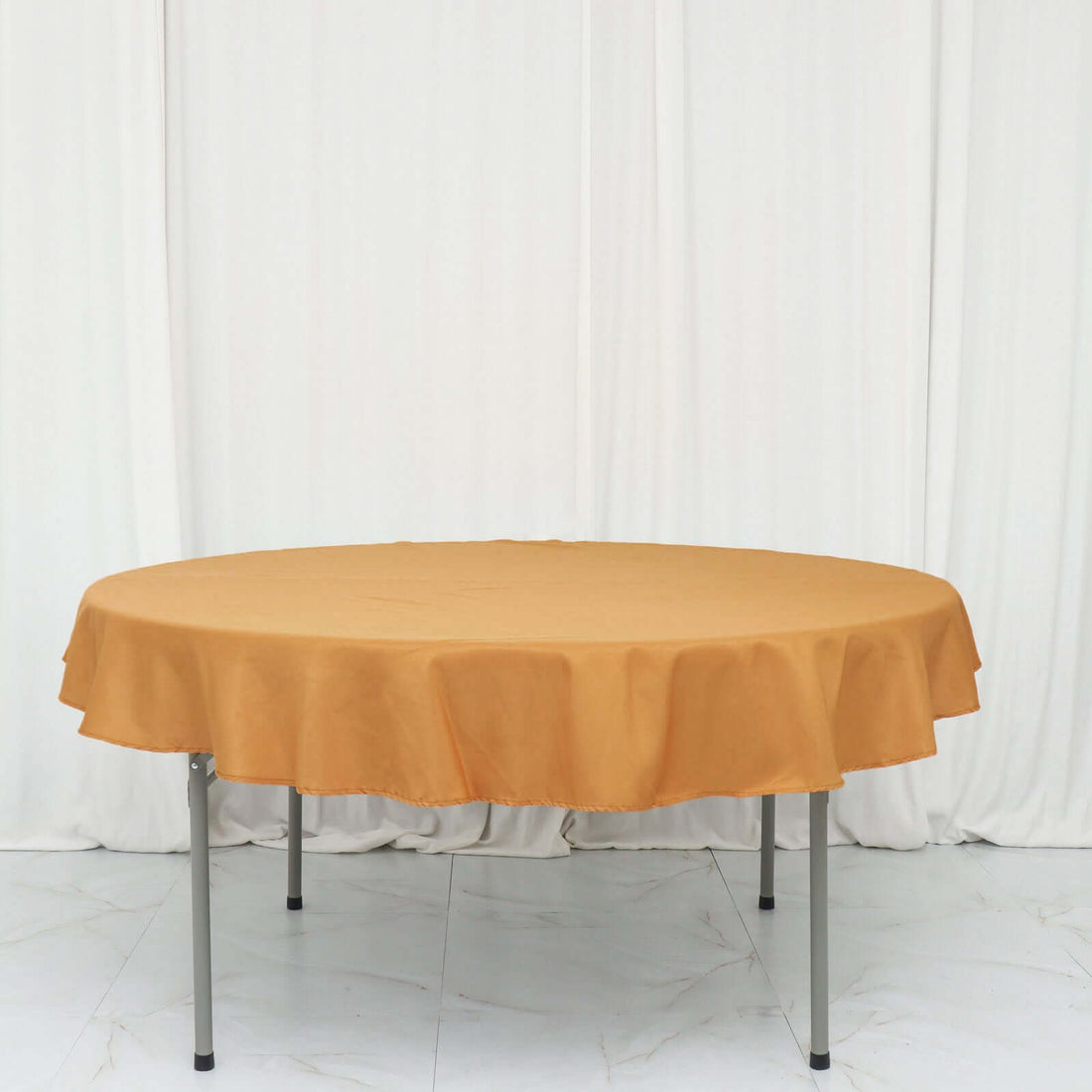Round table covered with a mustard yellow tablecloth