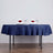 Elegant navy tablecloth set for a romantic dinner with glasses and rose-adorned napkins.