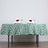 Table set with a green checkered tablecloth, glasses, and napkins with roses.