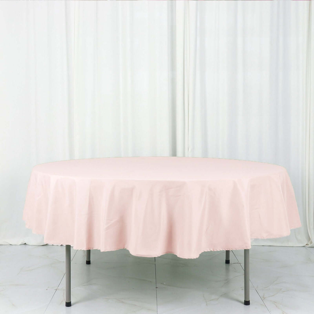 Round pink tablecloth on a white backdrop