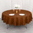 Round brown tablecloth on a dining table set with plates and glasses.