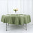 Olive green tablecloth on a round table set for dining with floral centerpiece.