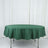 Green round tablecloth draped over a table against a light background.