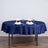 Navy tablecloth with elegant napkin folds and roses for dining setup.
