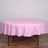 Round pink tablecloth on a wooden table.