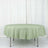 Round green tablecloth on a table against a white backdrop.