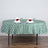 Green and white checkered tablecloth on a dining table with elegant napkins and glasses.