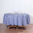 Blue and white checkered tablecloth on a round table with glassware.