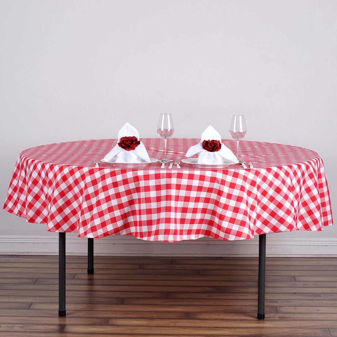 Red and white checkered tablecloth with elegant napkin presentation.