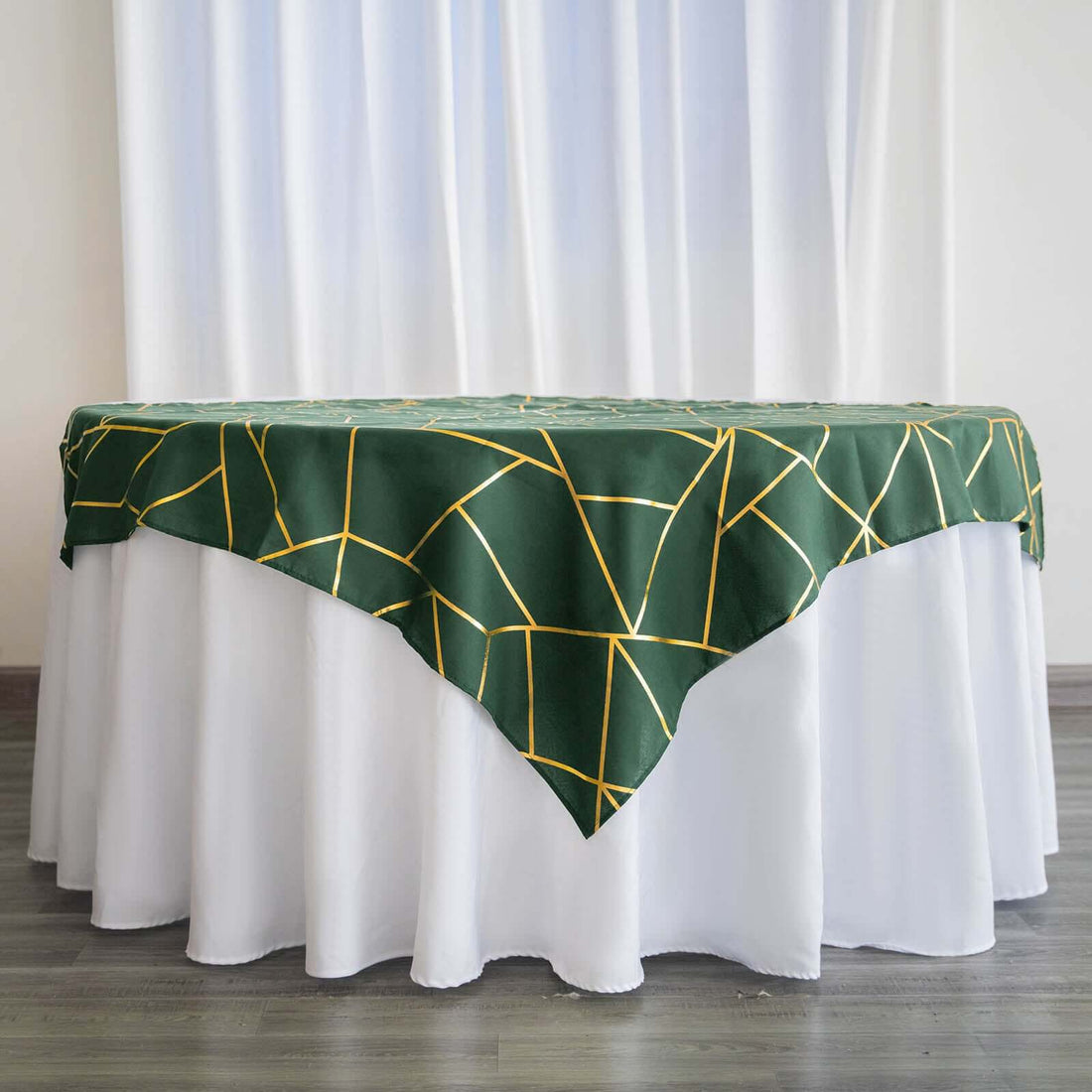 Green tablecloth with yellow geometric design draped over a white table.