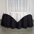 Table with gold geometric patterned tablecloth on a black skirt.