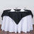 Elegant black tablecloth on a white table setting with glassware and napkins.