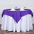 Purple table cover elegantly draped over a white table with dining setup.