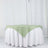 Green tablecloth draped over a white table with a smooth finish