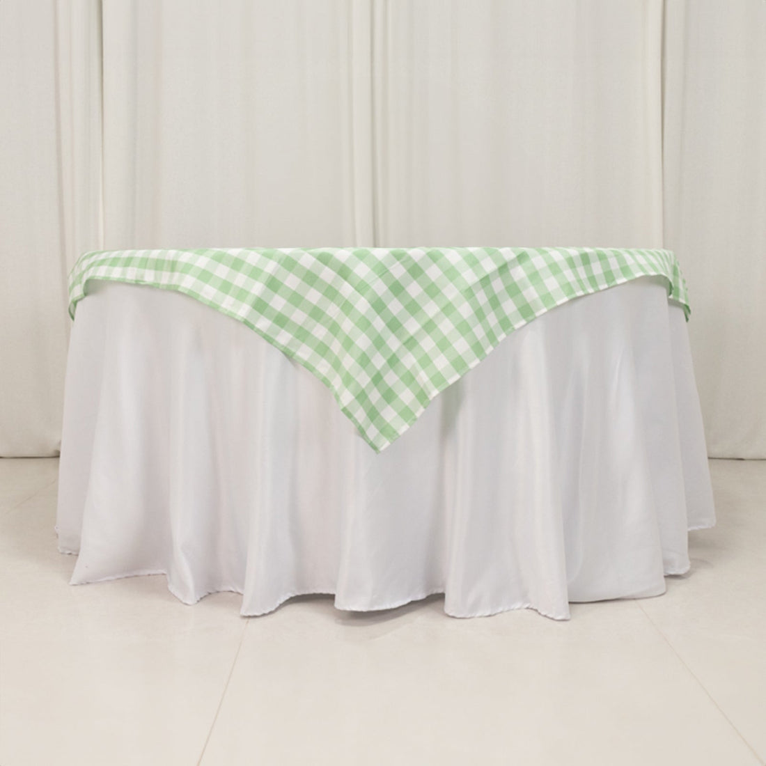 Green and white checkered tablecloth draped over a white table.