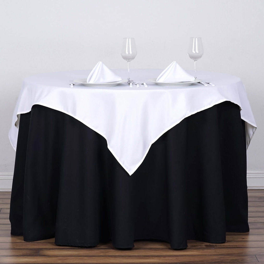Table set with white and black linens, glasses, and napkins for an elegant dining experience.