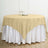 Round beige tablecloth draped over a white table