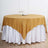 Round gold tablecloth draped over a white table skirt.