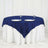 Navy blue tablecloth draped over a round table with plates and glasses