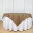 Brown tablecloth draped over a round table with a white skirt.